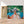 Première image de la peinture par numéro, Balade en Pirogue , dans un cadre en bois sur du parquet.