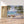 Première image de la peinture par numéro, Barques sur une Île Déserte , dans un cadre en bois sur du parquet.