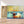 Première image de la peinture par numéro, Bateaux et Coucher de Soleil , dans un cadre en bois sur du parquet.