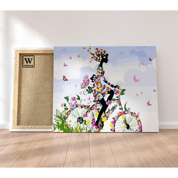 Première image de la peinture par numéro, Cycliste Fleurie , dans un cadre en bois sur du parquet.
