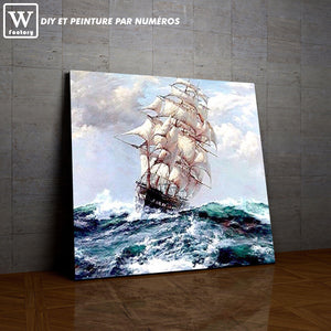 Première image de la peinture par numéro, Navire sur Mer Agitée , dans un cadre en bois sur du parquet.