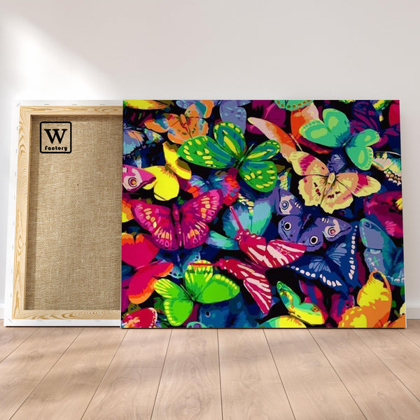 Première image de la peinture par numéro, Amas de Papillons , dans un cadre en bois sur du parquet.