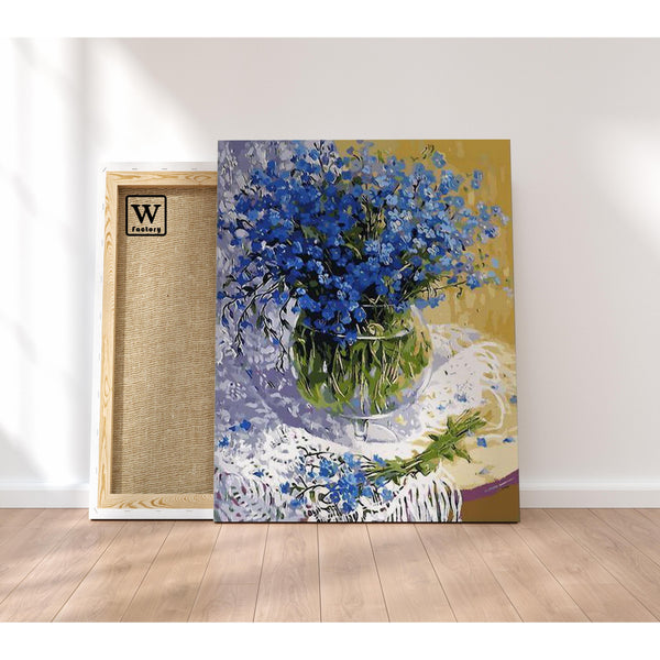 Première image de la peinture par numéro, Fleurs Bleues , dans un cadre en bois sur du parquet.