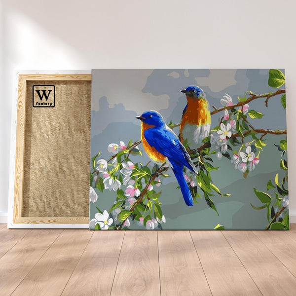 Première image de la peinture par numéro, Oiseaux Bleus , dans un cadre en bois sur du parquet.