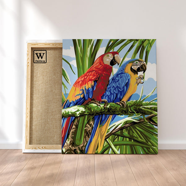 Première image de la peinture par numéro, Perroquets Inséparables , dans un cadre en bois sur du parquet.