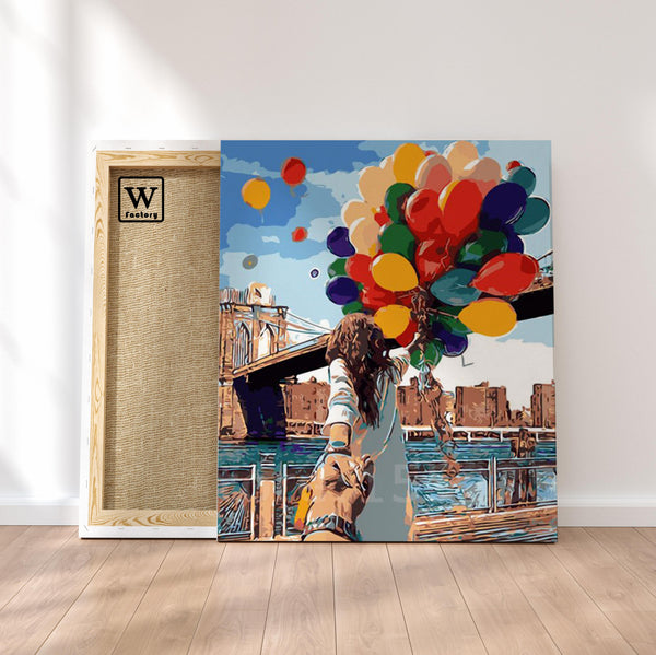 Première image de la peinture par numéro, Un Couple et des Ballons , dans un cadre en bois sur du parquet.