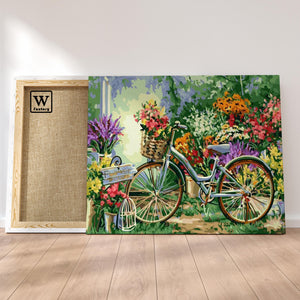 Première image de la peinture par numéro, Vélo Fleuri , dans un cadre en bois sur du parquet.