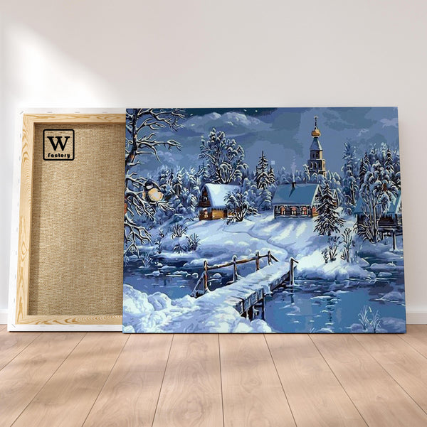 Première image de la peinture par numéro, Village de Noël , dans un cadre en bois sur du parquet.